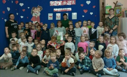 Zdjęcie grupowe dzieci, nauczycielek i gościa z biblioteki podczas zajęć